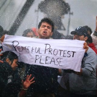 Protesters react as Indian police officers use a water cannon to disperse them near the India Gate as they protest against the gang rape and brutal beating of a 23-year-old student on a bus last week, in New Delhi, India, Sunday, Dec. 23, 2012. The attack last Sunday has sparked days of protests across the country. (AP Photo/ Saurabh Das)